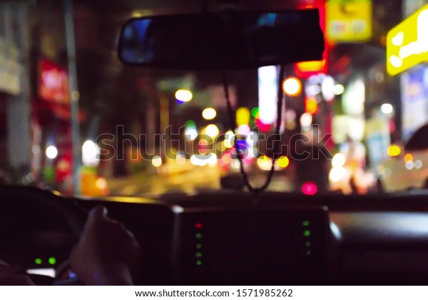 Defocused bokeh of light\
on road in dark night shoot picture from the inside of car,\
abstract nightlife, colorful street, way in the city,\
transportation at night\
concept