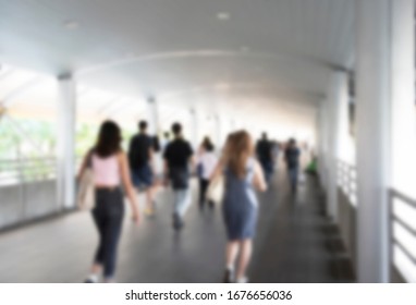 Defocused crowd wearing medical masks for virus protection and walking in walkway, blurred background, coronavirus, china covid-19 virus epidemic, pandemic, outbreak and air pollution concept