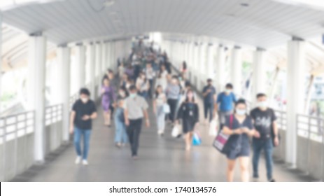 Defocused Crowd Wearing Medical Masks For Virus Protection And Walking In Walkway, Blurred Background, Coronavirus, China Covid-19 Virus Epidemic, Pandemic, Outbreak And Air Pollution Concept