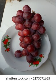 Defocused Dark Red Grapes On A White Plate 