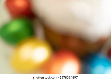 Defocused Easter background with blurred painted Easter eggs and Easter cake. Happy Easter concept