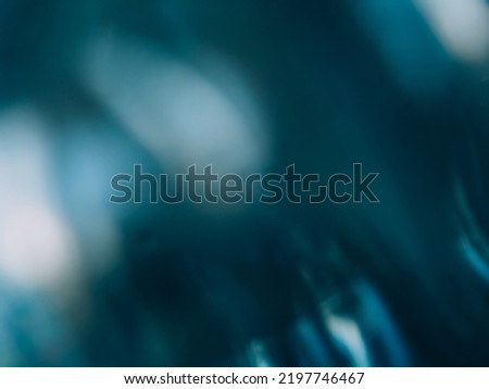 Defocused glow background. Light flare. Beam reflection. Blur white teal blue color smeared glare flecks on dark abstract copy space texture.