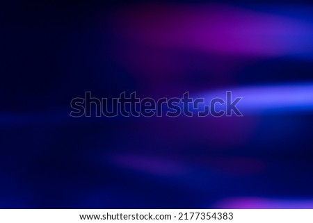 Defocused glow overlay. Fluorescent light leak. Sci-Fi illumination. Blur neon navy blue magenta pink color flare flecks on dark modern abstract background.