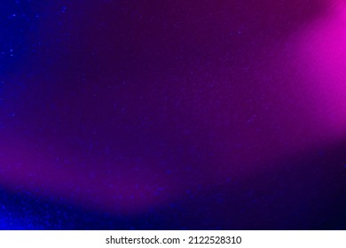 Defocused glow overlay. Grain texture. Bokeh radiance. Blur neon magenta pink blue color light flare shiny sparkles pattern on dark abstract background.