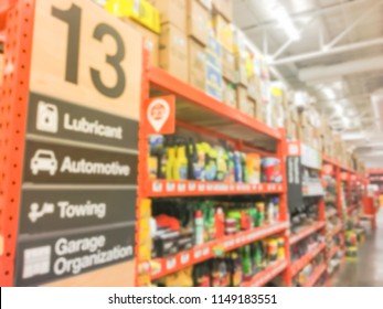 Defocused Home Improvement Retailer Store With Racks Of Lubricant, Automotive, Towing, Garage Organization. Blurred Image Background Of Large Hardware Store In America