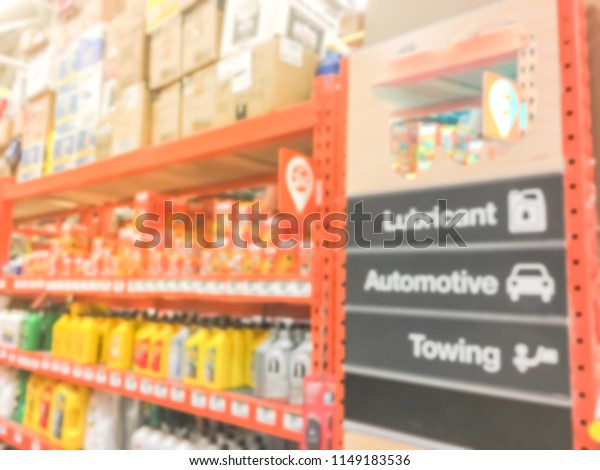 Defocused home\
improvement retailer store with racks of lubricant, automotive,\
towing, garage organization. Blurred image background of large\
hardware store in\
America