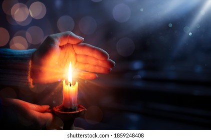 Defocused Hope Concept - Hands Holding Candle With Shining Flame And Blurry Lights - Powered by Shutterstock