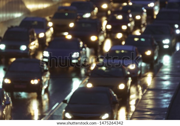 Defocused image of hard night for drivers. Big\
traffic in the city. In the summer urban highway filled cars. To be\
late. Long exposure. For greeting card design, postcard template,\
guide, poster.