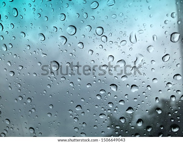 Defocused image, raindrop on car windshield,\
colorful bokeh with street light at evening.Driving car in heavy\
rain storm,traffic in the city on a rainy\
day.