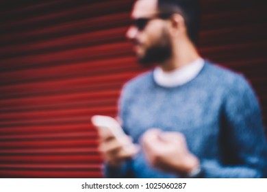 Defocused Image Of Young Male Person Using Smartphone For Sending Messages And Chatting In Networks Outdoors,man Silhouette Holding Cellular, Blurred Background Copy Space