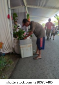 Defocused Images Of A Child Picking Up Trash In A Trash Can At An Exhibition