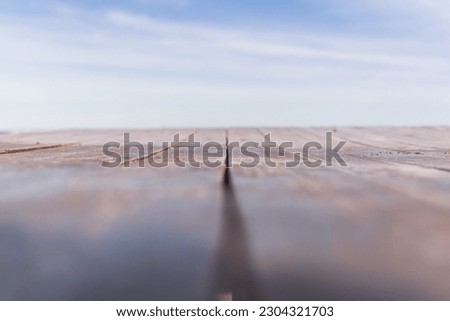 Defocused linear background with an old wood and lightblue sky with white clouds