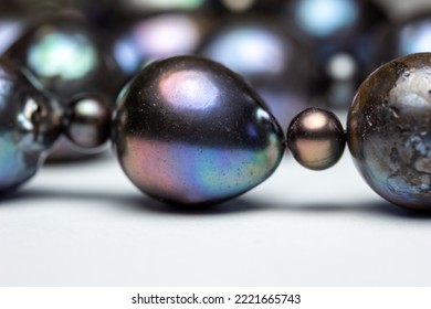 Defocused macro abstract texture background of a dark blue and black baroque pearl necklace with natural surface scarring and aberrations