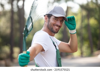 Defocused Man Raking Leaves At Garden