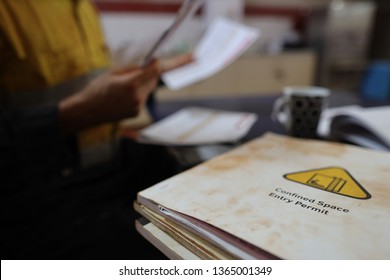 Defocused Of Miner Seating On The Chair Double Checking Of Job Hazard Analysis (JSA) With JSA Confined Space Templates Forms On The Table Perth, Australia
