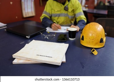 Defocused Of Miner Seating On The Chair Written Job Hazard Analysis (JSA) With JSA Templates Forms On The Table Construction Mine Site Perth, Australia