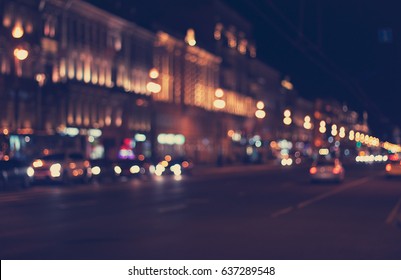 Defocused Night City Life: Cars, Cyclist And Street Lamps