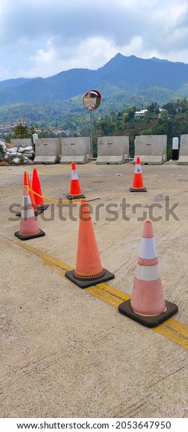 Defocused Photo of a road\
divider cone arranged at a road bend in the Cicalengka area,\
Indonesia