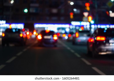 Defocused picture of night street car traffic - view from road. Colorful night life background.