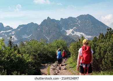 Defocused rear view of a group of young hikers on a mountain path. Tatras, Poland