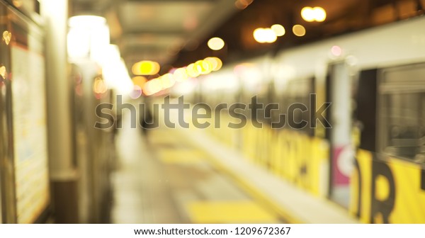 Defocused scene of urban train leaving the station\
at night