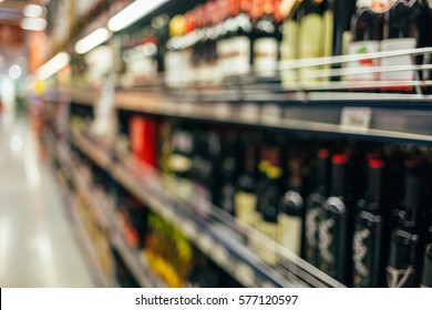 Defocused Shelves With Liquor Wine Bottles In Supermarket. Liquor Wine Store Shelf Out Of Focus