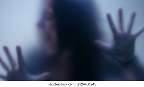 Defocused shot of person trapped in emotional problems behind glass depression concept