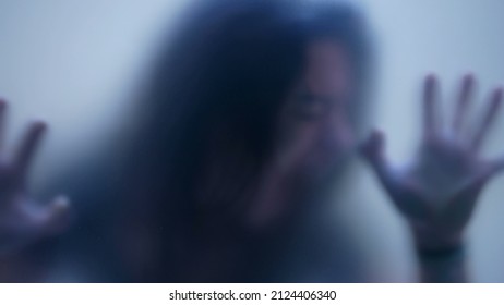 Defocused shot of person trapped in emotional problems behind glass depression concept