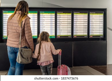 Defocused Silhouette Of Family, Young Girl And Her Mother On Airport Terminal. Checking Arrival And Departure Board For Their Flight. Dublin, Ireland