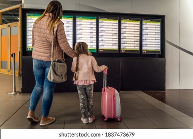 Defocused Silhouette Of Family, Young Girl And Her Mother On Airport Terminal. Checking Arrival And Departure Board For Their Flight. Dublin, Ireland