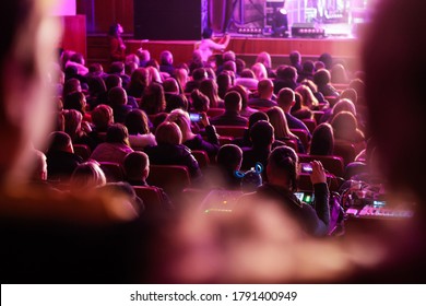 Defocused spectators sit in the hall and watch a concert. People in the auditorium watching the performance. Theater audience. Out of focus - Shutterstock ID 1791400949