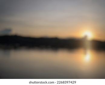 defocused sunset behind trees by the river