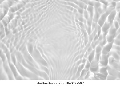 De-focused. Transparent clear calm water surface texture desaturated gray colored with splashes and bubbles. Trendy abstract nature background. Water waves in sunlight. Copy space for product mockup