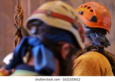 Defocused white and orange safety fall head protection helmet industrial rope access working at height must be worn when working on open field 