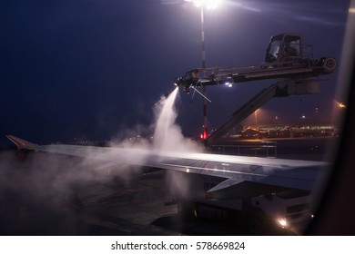 Defrost wings before flight in winter time. Airport in the freezing cold winter. Deicing of the airplane before flight.