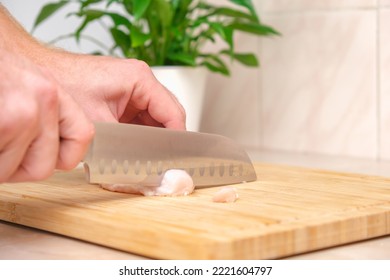 Defrosted Raw Chicken Fillet On Cutting Board. Slicing Fresh Raw Chicken Breast With Sharp Knife For Cooking Chopped Chicken Cutlets On A Bamboo Wooden Cutting Board For Slicing. Kitchen Knife Test.