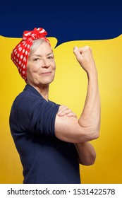 Defy Age Concept: Mature Woman With Clenched Fist Rolling Up Her Sleeve, Background Template, Copy Space