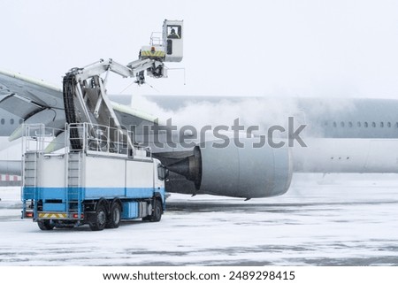 De-icing the aircraft before the flight. The deicing machine sprinkles the wing of a passenger plane with antifreeze. Winter at the airport. Snow. Aviation handling. Steam in the cold. Airport service