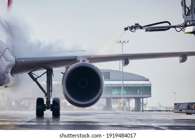 Deicing of aircraft wing before flight. Winter frosty day at airport. 