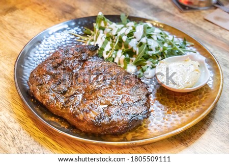 Deicious medium rare beef steak perfectly grilled over fire with side dishes served