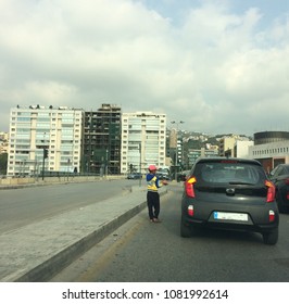 Dekwane Beirut Subburb/Lebanon- April 30 2018: Very Young Child Trying To Sell Chewing Gums At A Red Light Despite Policy To Prevent Human Traffic 