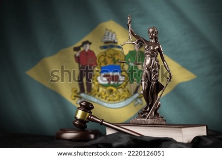 Delaware US state flag with statue of lady justice, constitution and judge hammer on black drapery. Concept of judgement and punishment