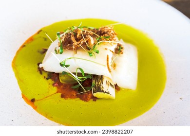 A delectable fillet of fish, expertly cooked and served on a clean, white plate in an upscale restaurant setting, showcasing the epitome of fine dining cuisine.