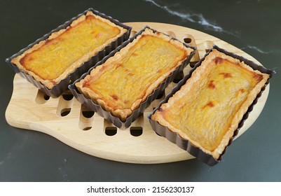 Delectable Fresh Baked Homemade Pumpkin Tartlets in Baking Molds on the Wooden Breadboard