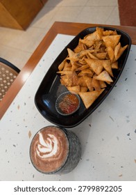 A delectable spread of snacks and coffee on a trendy caf? table.