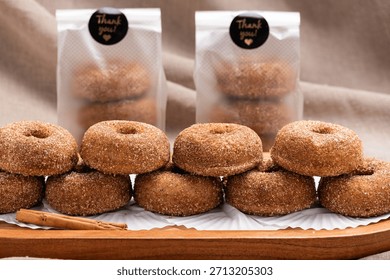 A delectable stack of freshly baked cinnamon sugar donuts presented on a rustic wooden tray. Citron donuts.