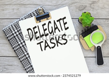 DELEGATE TASK text on a white page on a bright notepad on the table