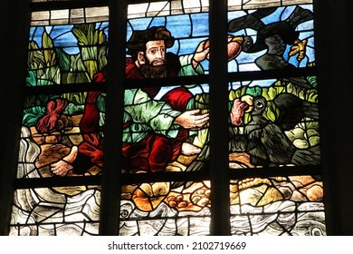 Delft, the Netherlands - October 2021: stained glass window of Elijah the prophet fed by ravens by glazier Joep Nicolas in the Old Church in Delft
