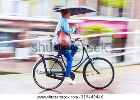 DELFT, NETHERLANDS - SEPTEMBER 04, 2015: unidentified cyclist on a rainy day. In NL almost as many kilometres are covered by bicycle as by train. It is estimated that they have at least 18 mio bicycle