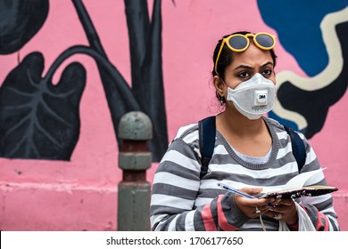 Delhi, India - 07/03/2020: A Medical Worker Wearing A Protective N95 Face Mask By 3M Writing Important Information In A Note Book While Working On Contact Tracing Of Covid 19 Or Corona Virus Cases.